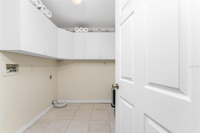 laundry area featuring cabinets, hookup for a washing machine, light tile patterned floors, and hookup for an electric dryer