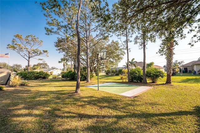 view of community featuring basketball court and a lawn