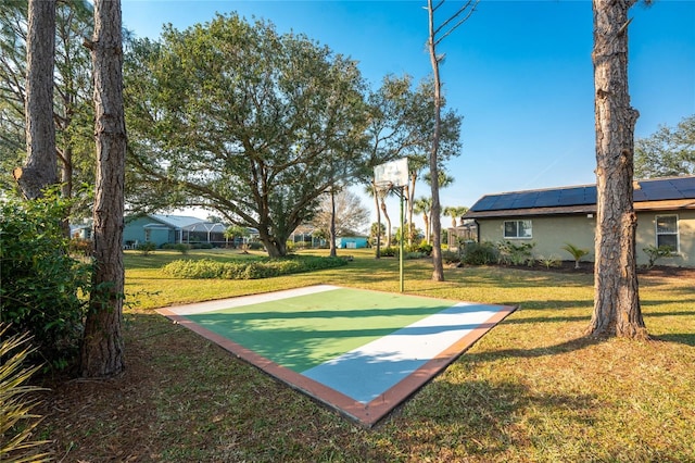 view of sport court with a lawn