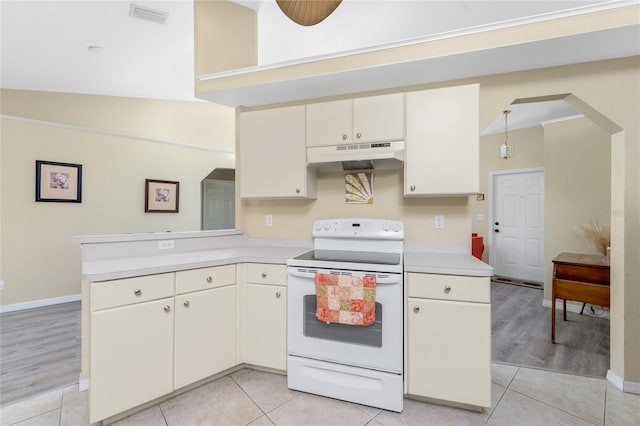 kitchen with white electric range, kitchen peninsula, and light tile patterned floors