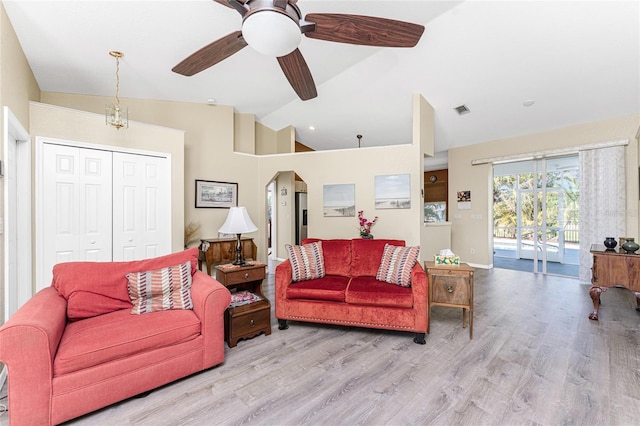 living room featuring ceiling fan, lofted ceiling, and light wood-type flooring