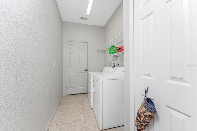 laundry room featuring separate washer and dryer and light tile patterned floors