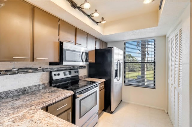 kitchen with tasteful backsplash, stainless steel appliances, and a raised ceiling