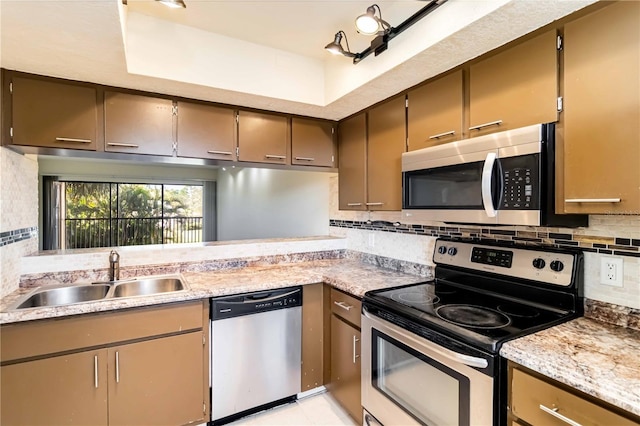 kitchen with appliances with stainless steel finishes, sink, and backsplash