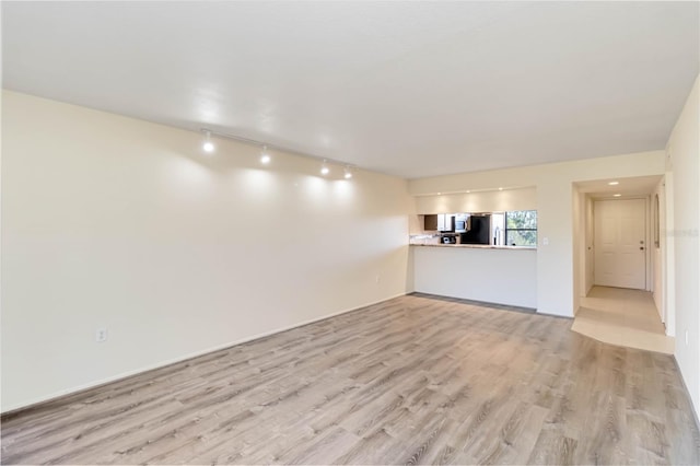 unfurnished living room featuring light hardwood / wood-style flooring and track lighting