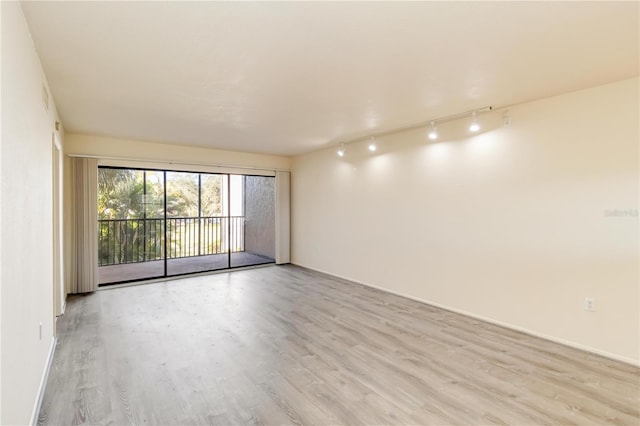 spare room with rail lighting and light hardwood / wood-style floors