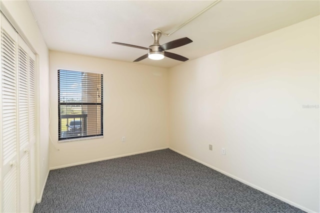 unfurnished room with ceiling fan and dark colored carpet