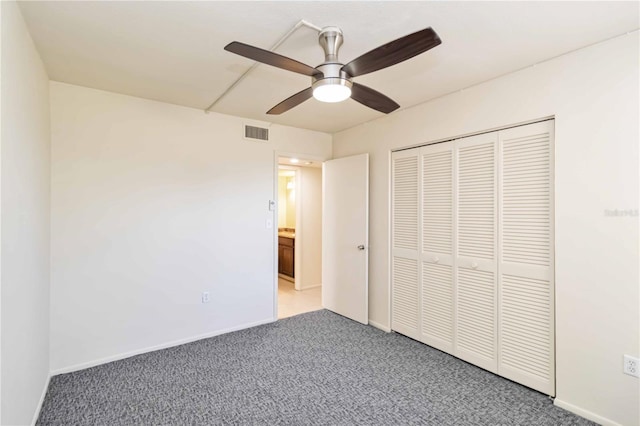 unfurnished bedroom featuring carpet, ceiling fan, and a closet