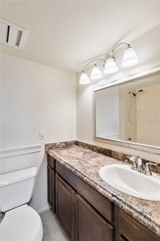 bathroom featuring walk in shower, vanity, toilet, and a textured ceiling