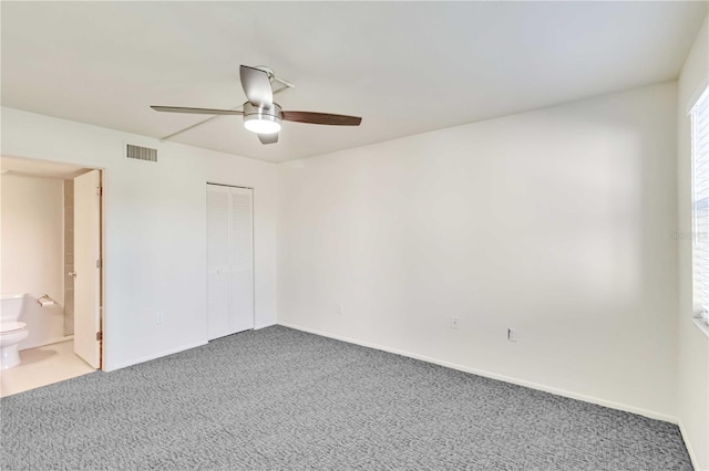 unfurnished bedroom featuring ceiling fan, connected bathroom, carpet floors, and a closet