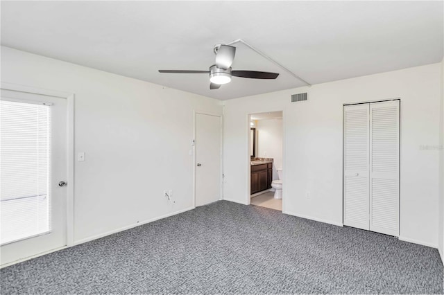 unfurnished bedroom featuring a closet, ensuite bathroom, ceiling fan, and carpet flooring