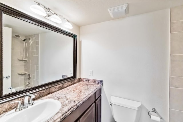 full bathroom with vanity, tiled shower / bath, and toilet