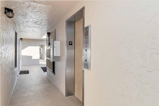 hallway with a textured ceiling