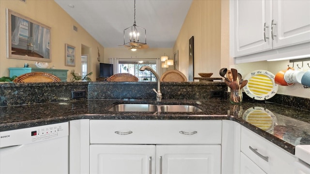 kitchen featuring sink, white cabinetry, dark stone countertops, white dishwasher, and pendant lighting