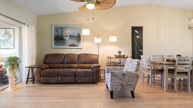 living room with a healthy amount of sunlight, lofted ceiling, and light wood-type flooring