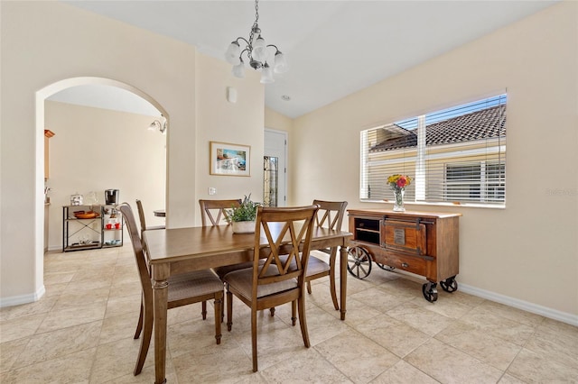 tiled dining area featuring a notable chandelier and vaulted ceiling