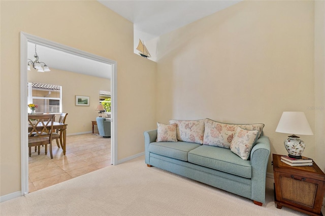 carpeted living room featuring a notable chandelier