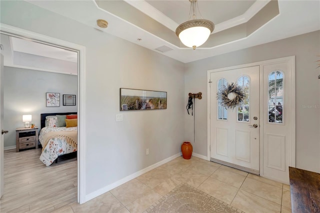 entrance foyer featuring light tile patterned floors and a tray ceiling