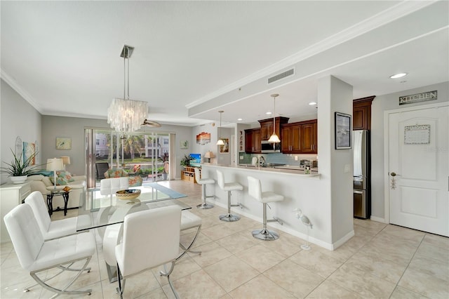 tiled dining space featuring crown molding and a notable chandelier