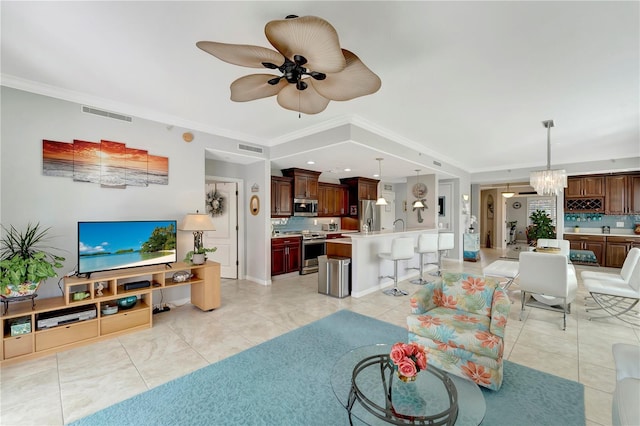 living room featuring ceiling fan with notable chandelier and ornamental molding