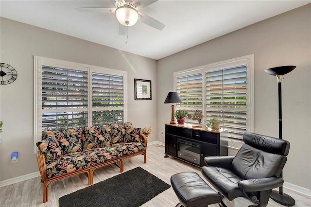 living room featuring ceiling fan, a healthy amount of sunlight, and light wood-type flooring