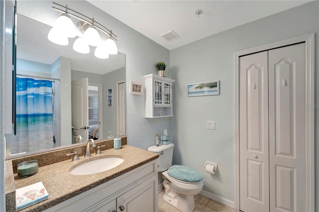 bathroom with tile patterned flooring, vanity, walk in shower, and toilet