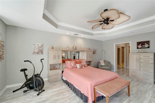 bedroom with light hardwood / wood-style flooring, ornamental molding, a raised ceiling, and ceiling fan