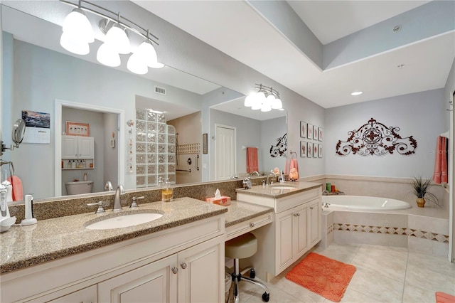 bathroom featuring tiled tub, vanity, tile patterned floors, and toilet