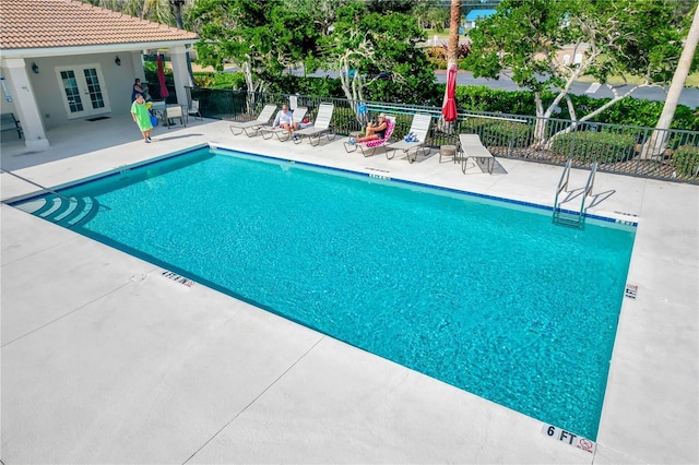 view of swimming pool with a patio area and french doors