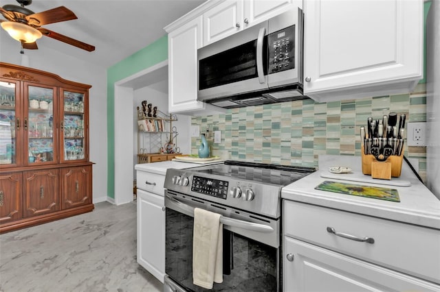 kitchen with white cabinetry, ceiling fan, stainless steel appliances, and decorative backsplash