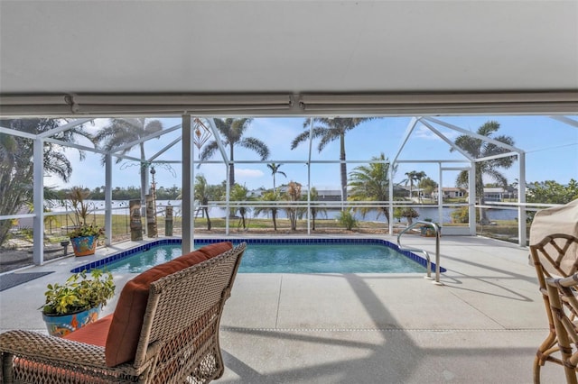 view of swimming pool with a water view, glass enclosure, and a patio area