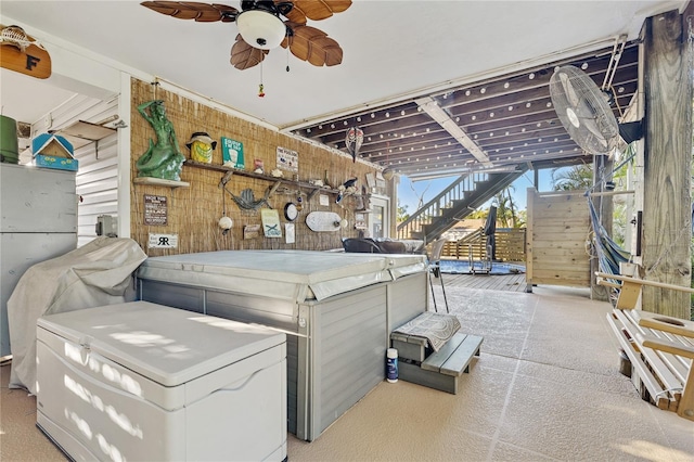 misc room featuring ceiling fan, light colored carpet, and wooden walls