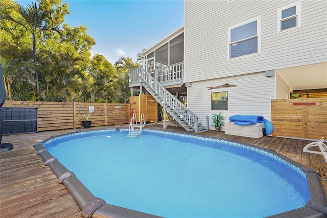 view of swimming pool with a sunroom and a deck