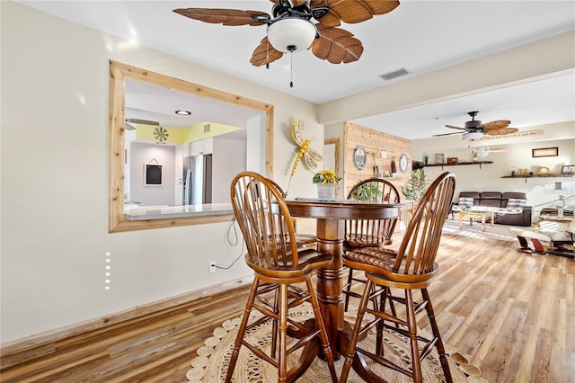 dining area with hardwood / wood-style floors and ceiling fan