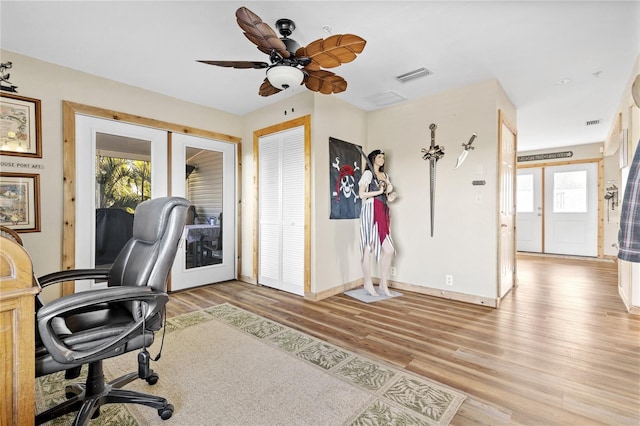 home office with plenty of natural light, french doors, ceiling fan, and light wood-type flooring