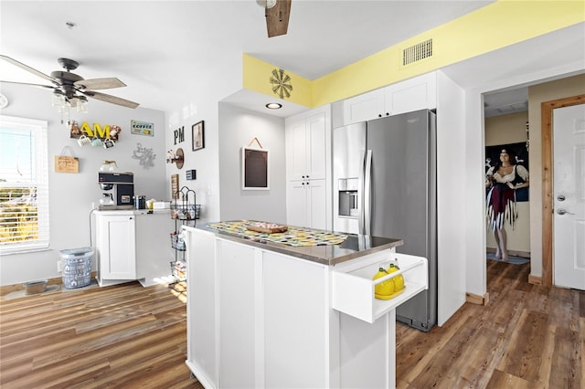 kitchen with dark hardwood / wood-style flooring, stainless steel fridge with ice dispenser, kitchen peninsula, and white cabinets