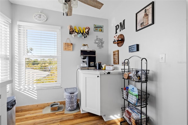 bar with white cabinetry, hardwood / wood-style flooring, and ceiling fan