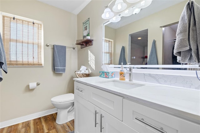 bathroom with hardwood / wood-style floors, vanity, a wealth of natural light, and toilet