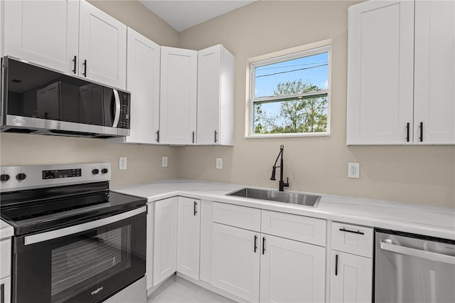 kitchen featuring stainless steel appliances, sink, and white cabinets