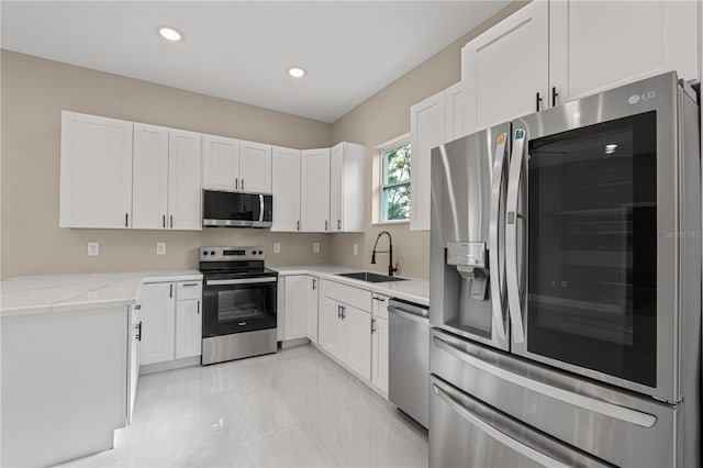 kitchen with stainless steel appliances, white cabinetry, and sink