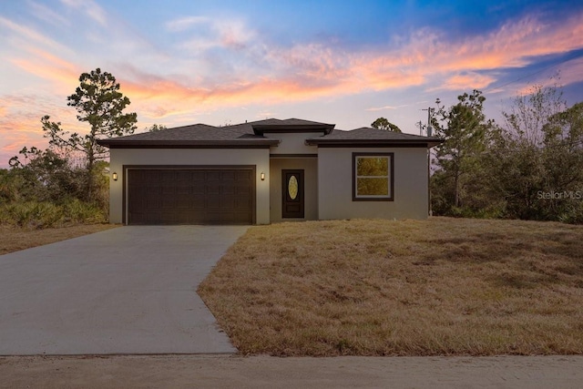 view of front of home featuring a garage, driveway, and stucco siding