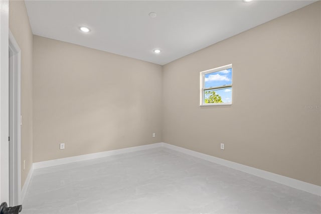 empty room with concrete flooring, recessed lighting, and baseboards