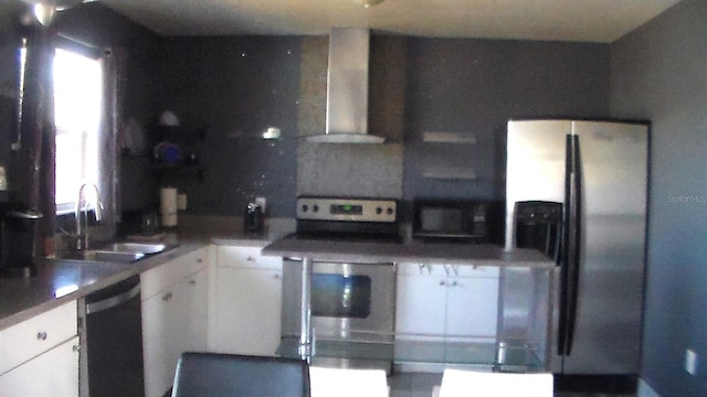 kitchen with white cabinetry, wall chimney range hood, sink, and black appliances