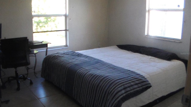 tiled bedroom featuring multiple windows