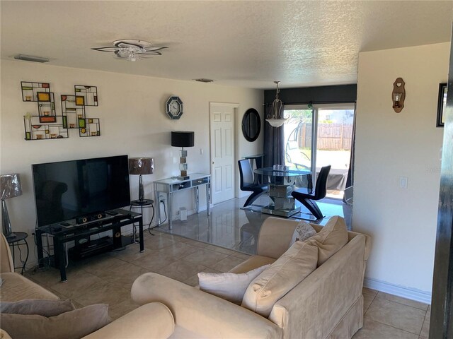 3380 Maple Ter, Port Charlotte, FL 33952 - tiled living room with a textured ceiling, baseboards, ceiling fan, and visible vents