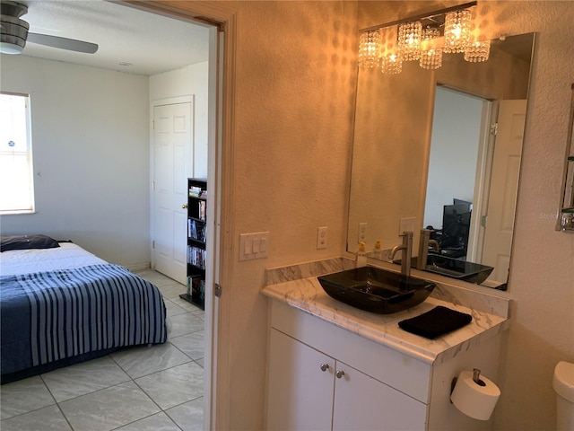 3380 Maple Ter, Port Charlotte, FL 33952 - bathroom with tile patterned floors, toilet, vanity, ceiling fan with notable chandelier, and a textured wall