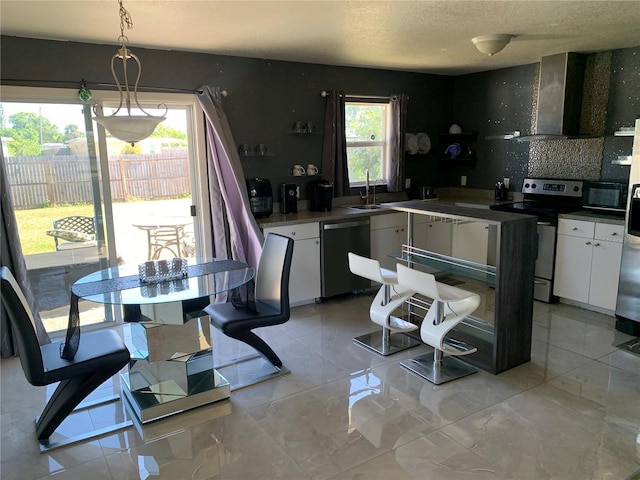 3380 Maple Ter, Port Charlotte, FL 33952 - kitchen with electric range, dishwasher, white cabinets, black microwave, and wall chimney exhaust hood