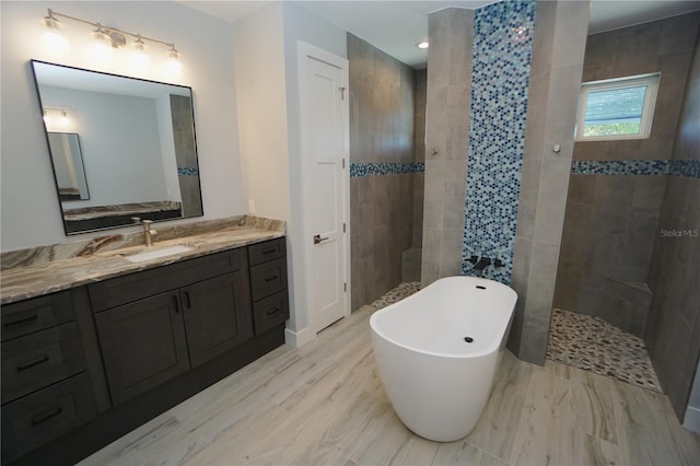 bathroom featuring hardwood / wood-style flooring, vanity, and shower with separate bathtub