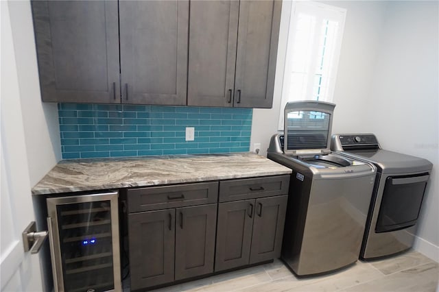 washroom with wine cooler, cabinets, and independent washer and dryer