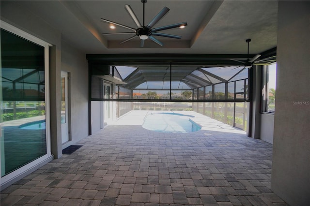 view of pool featuring ceiling fan, glass enclosure, and a patio area